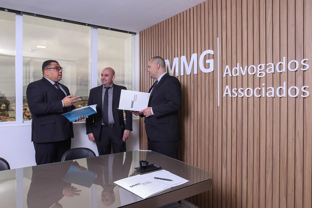 Foto ilustrativa com os advogados reunidos na sala de reunião do escritório de advocacia MMG Advogados Associados na cidade de Pelotas para discutir um processo.